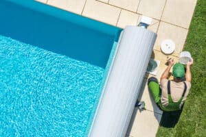 male employee from pool service company cleaning pool filter