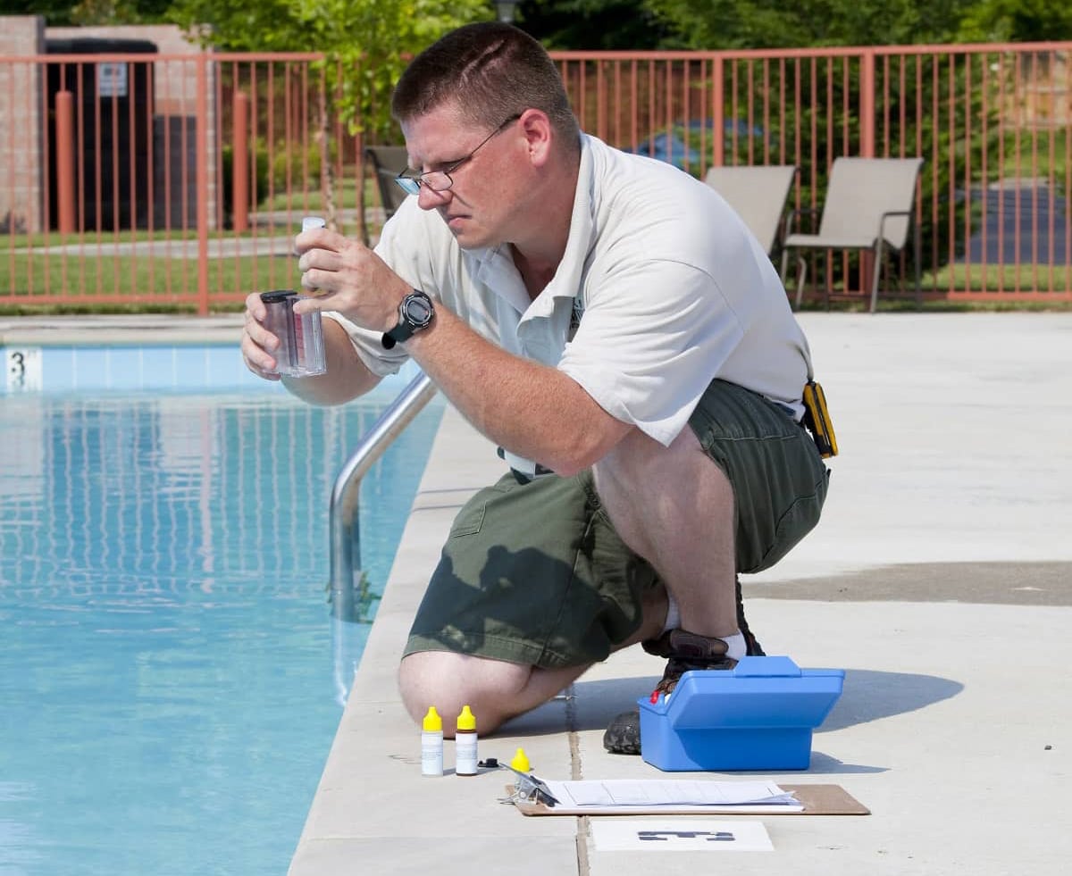 Pool technician using pool chemicals